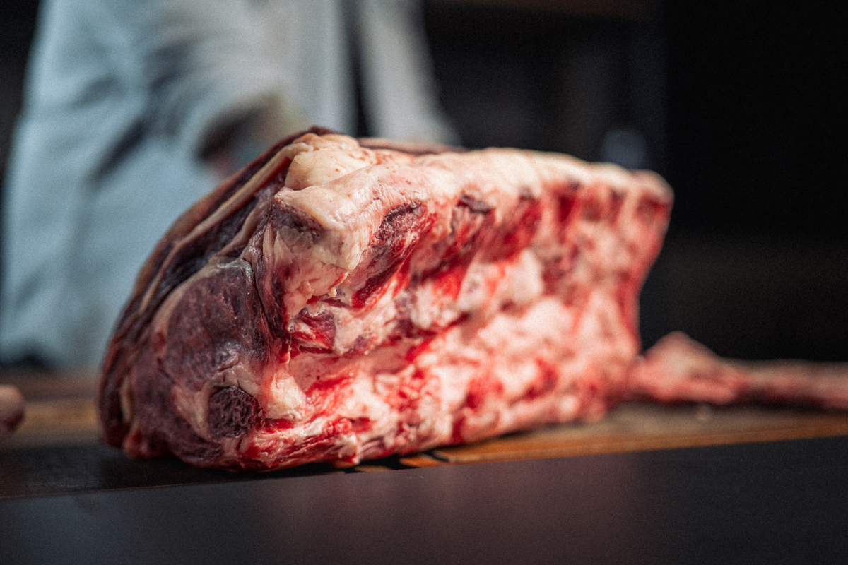 Usmażony antrykot medium rare pokrojony w poprzek włókien na desce